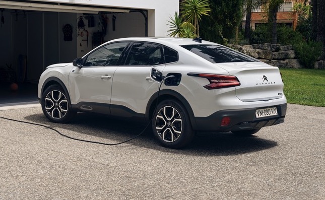 White Citroen e-C4X rear side profile view while charging